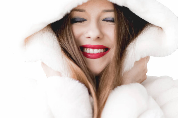 Kapüşonlu tüylü kürklü genç kadın, moda ve Noel tatilleri için kalın kışlık elbiseler. - Fotoğraf, Görsel