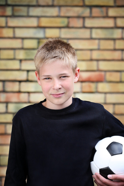 een jongen tegen een muur met een bal - Foto, afbeelding
