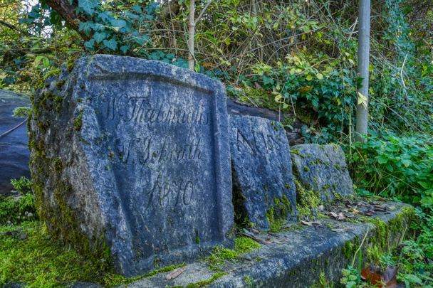Historische grafstenen aan de zijkant van een wandelpad bij de Dussel - Foto, afbeelding