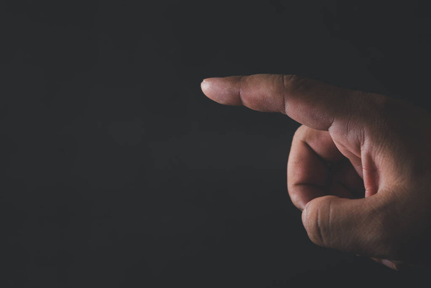 Close up of human finger point on a black background - Photo, Image