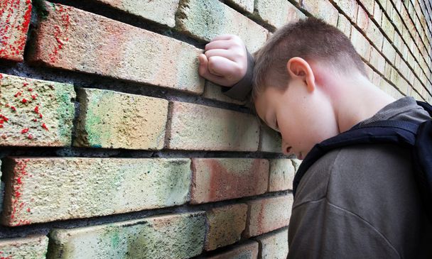 Upset boy against a wall - Photo, Image