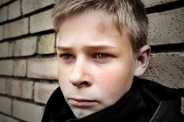 Расстроенный мальчик, прислонившийся к стене
 - Фото, изображение