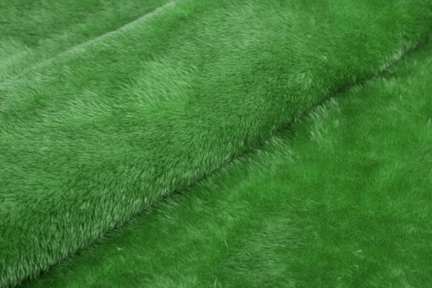 groene Karakul Abstract Kunstmatige textuur bont stof, achtergrond, close-up. pluizig materiaal achtergrond, kinderen speelgoed faux fur. - Foto, afbeelding
