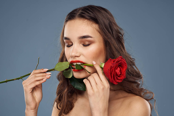 жінка з трояндою в руках голі плечі вечірній макіяж червоні губи
 - Фото, зображення