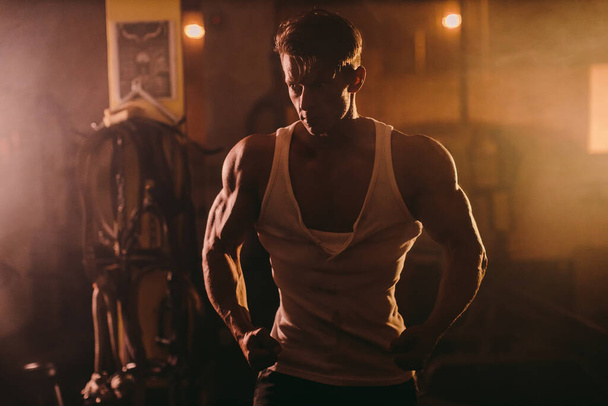 Brutalny muskularny mężczyzna pozowanie w siłowni - Zdjęcie, obraz
