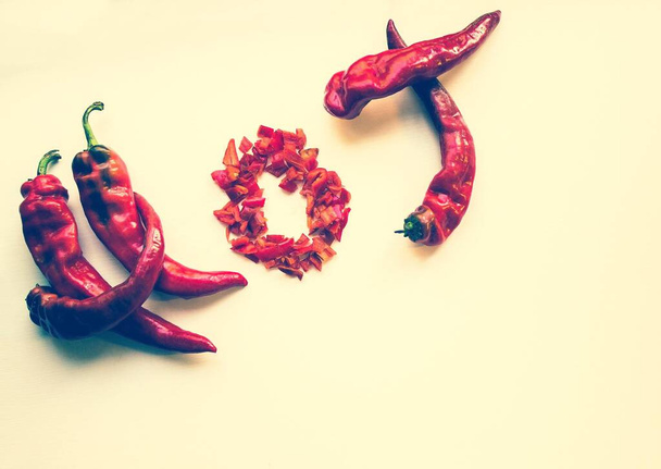 Hot pepper on a light background. The inscription is hot from the red pods. Toning, top view, copy space. - Photo, Image
