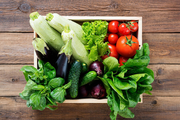 Légumes frais dans une boîte en bois sur fond en bois. - Photo, image