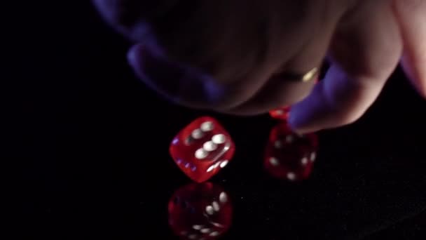 Pomalý pohyb válcování hracích kostek na černém stole.Rolling červené kasino kostky - Záběry, video