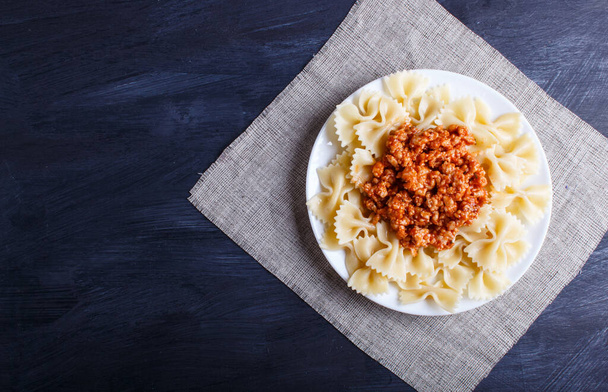 Farfalle bolognese pasta with minced meat on black wooden background. top view, copy space. - Fotografie, Obrázek