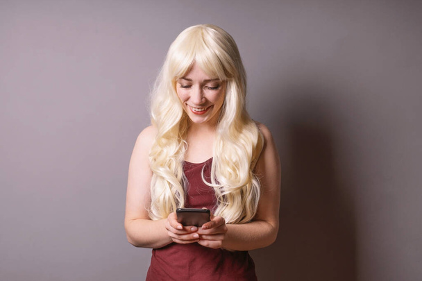 boldog fiatal nő nézi szöveges üzenet az ő smartphone vagy mobil - Fotó, kép