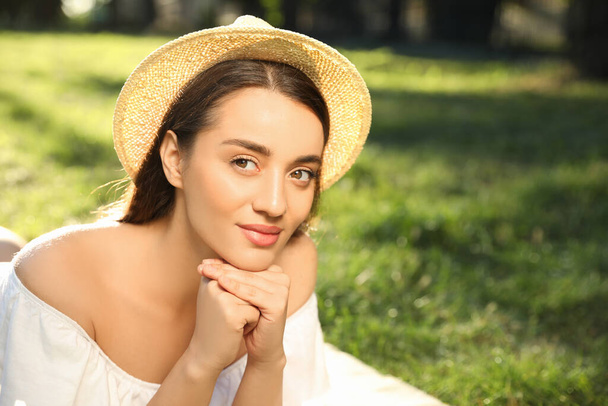 Beautiful young woman in park on sunny day - Foto, afbeelding
