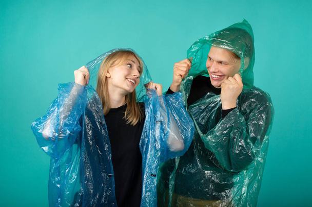 beautiful young man and woman in raincoats - Photo, Image