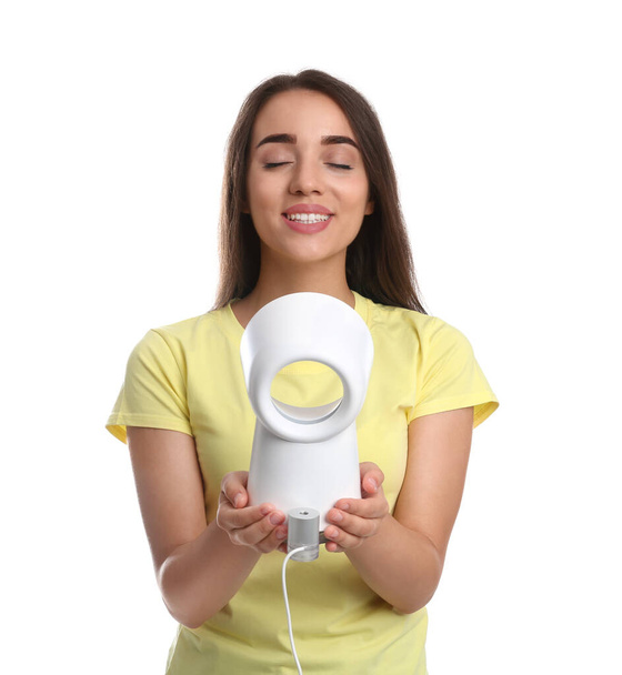 Woman enjoying air flow from portable fan on white background. Summer heat - Zdjęcie, obraz