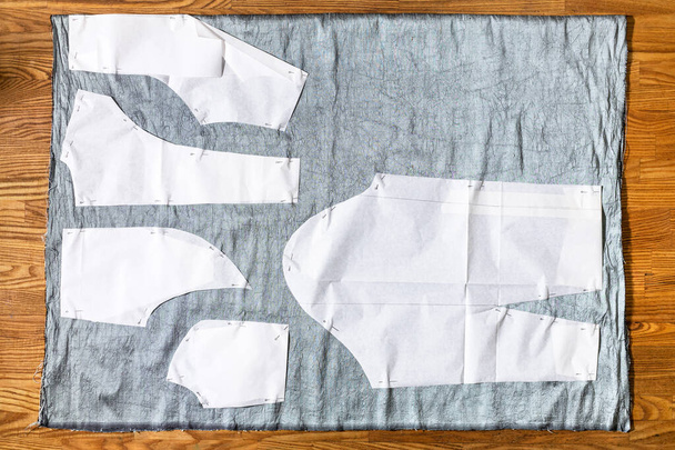 家庭のテーブルの上のグレーの布にドレスの紙の縫製パターンのレイアウトのトップビュー - 写真・画像
