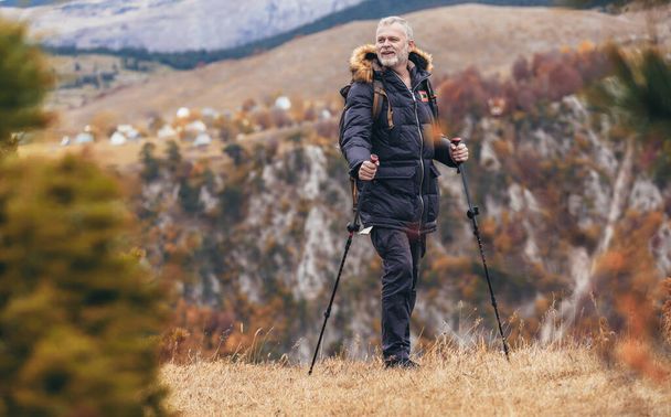 Happy mature man hiking in autumn - 写真・画像