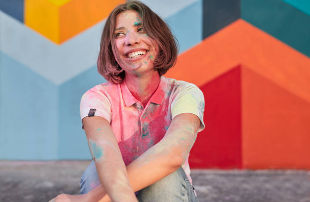 Cheerful young female covered with colorful paint - Foto, immagini