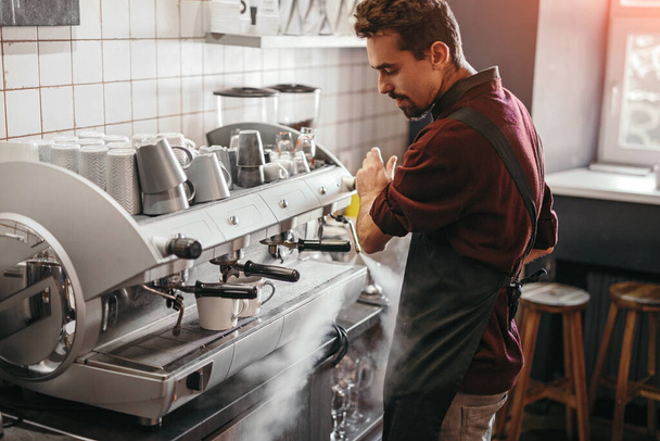Male barista preparing coffee in cafe - Фото, зображення