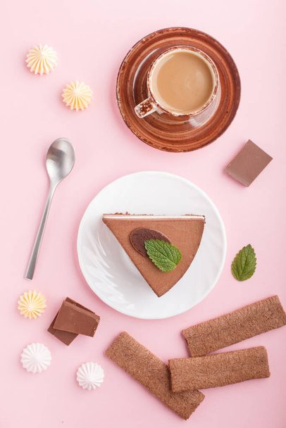 Cake with souffle milk chocolate cream with cup of coffee, meringues on a pink pastel background. top view, flat lay, close up. breakfast concept. - Photo, Image