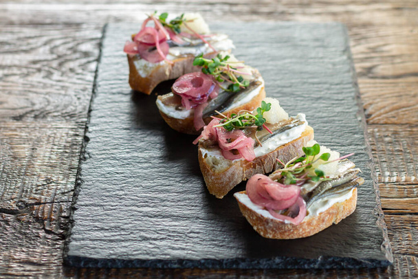 Тост или открытые сэндвичи с рыбой, сыром, луком, микрозеленью и икрой - Фото, изображение
