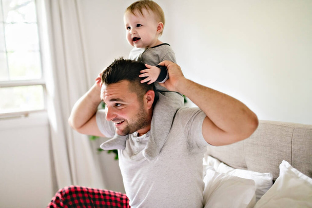A Father with cute baby son on bed at home - Fotoğraf, Görsel