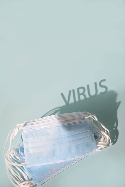 antiviral Medical protective mask on blue background, Prevent covid protection factor for virus, Disposable surgical face mask cover the mouth and nose, Healthcare and medical concept, shadow virus - Photo, Image