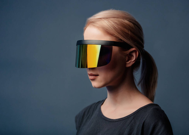Frau mit futuristischer Brille auf grauem Hintergrund  - Foto, Bild