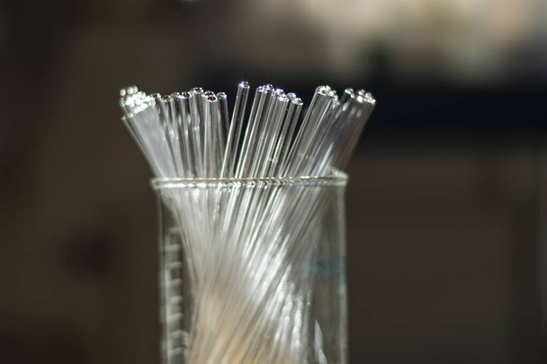 Различные чистые трубки ЯМР в стакане в химической лаборатории для биотехнологических исследований для разработки лекарственных препаратов - Фото, изображение