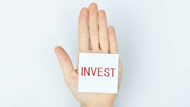 Text INVEST on stickers on the hand. Financial accounting, accounting concept. - Fotó, kép