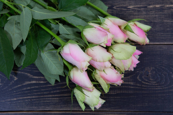 Beautiful bouquet of soft pink roses on a dark wooden background. - Foto, afbeelding