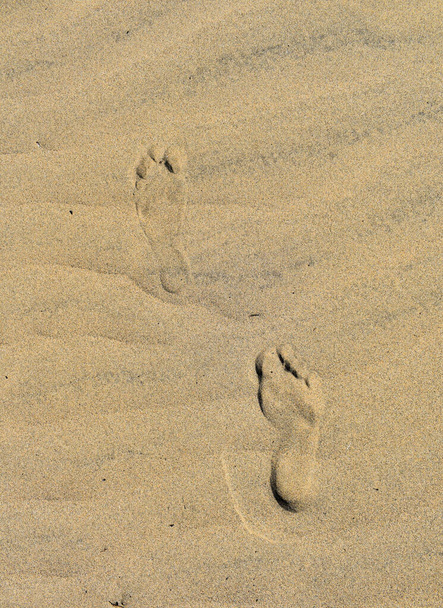 Ίχνη ποδιών στην άγονη άμμο της ερήμου. - Φωτογραφία, εικόνα