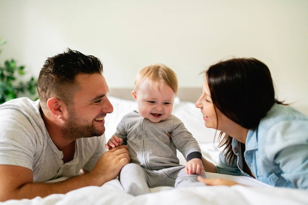 happy family mother, father and son at home in bed - Foto, Imagem