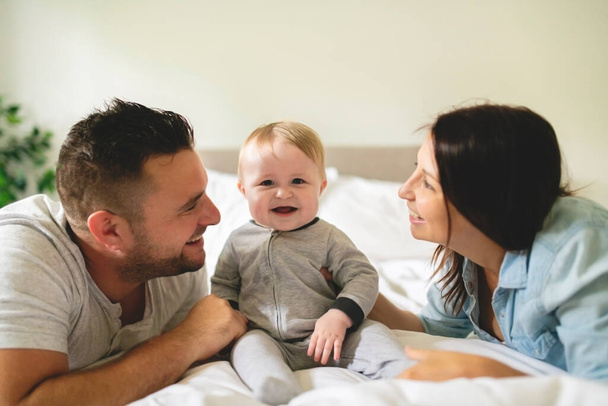 happy family mother, father and son at home in bed - Foto, Imagem