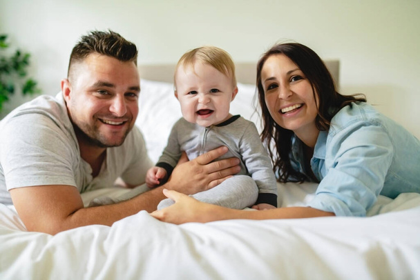 happy family mother, father and son at home in bed - Fotografie, Obrázek