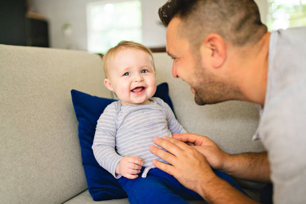 Father And Son Playing On Sofa Together - 写真・画像