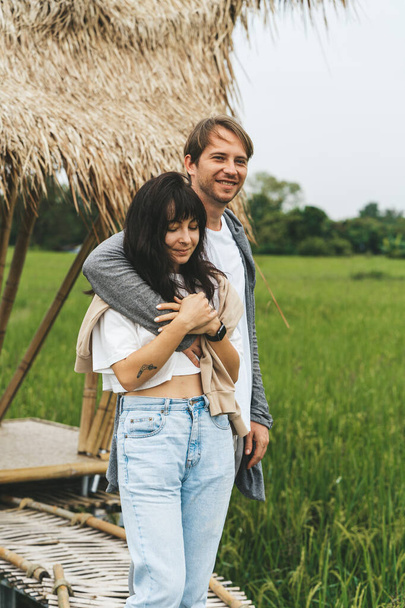 Пара закоханих стоїть біля бамбукового мосту на рисовому полі
 - Фото, зображення