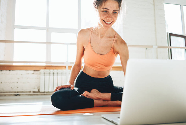 Yoga woman instructor taking online lesson using video call in laptop. Fitness instructor leads a lesson for class with group of people at home - Photo, image