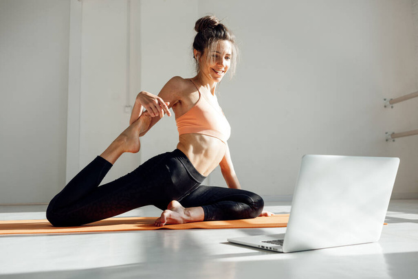 Yoga woman instructor taking online lesson using video call in laptop - Foto, afbeelding