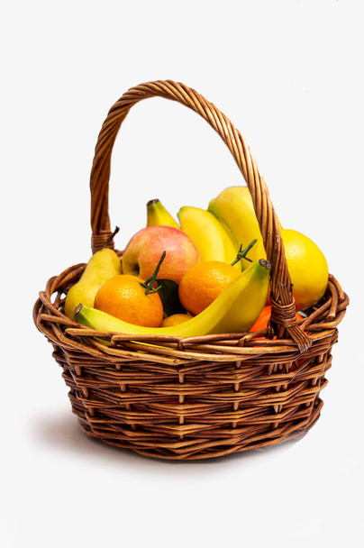 Various fruit in a brown basket isolated on white background - Zdjęcie, obraz