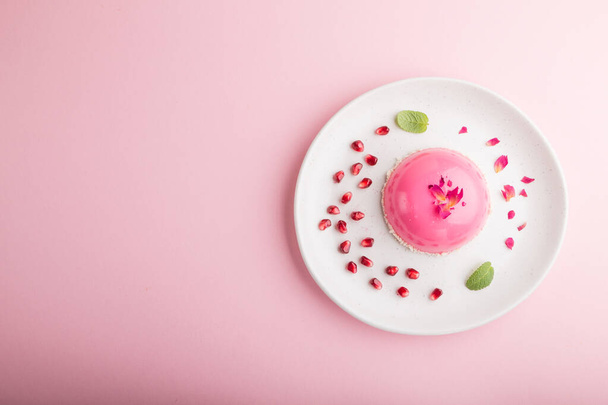 Rosafarbener Moussekuchen mit Erdbeere auf pastellrosa Hintergrund. Draufsicht, flache Lage, Kopierraum. - Foto, Bild