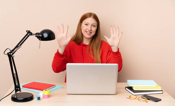 Молодая студентка на рабочем месте с ноутбуком, насчитывающим десять пальцев - Фото, изображение