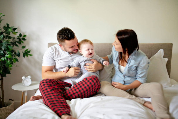happy family mother, father and son at home in bed - 写真・画像
