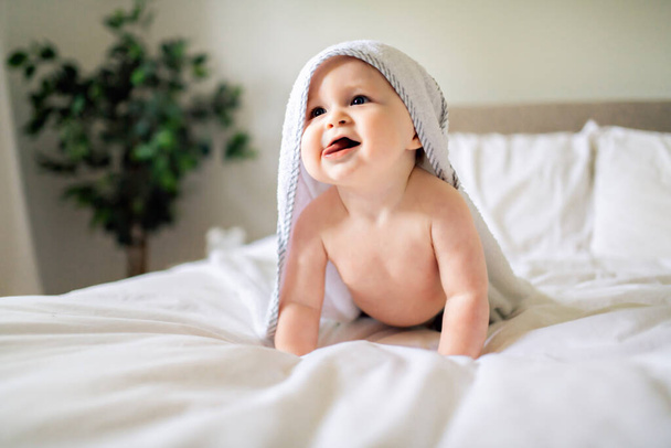 A cute Baby in white bedding at home - Foto, afbeelding