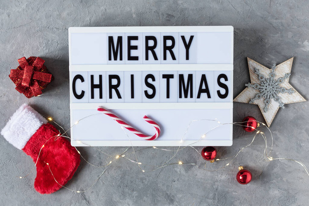 Sfondo natalizio con decorazione natalizia, bastoncini di zucchero natalizio e lightbox con Merry Christmas word top view su sfondo grigio. Biglietto di auguri di Natale. - Foto, immagini