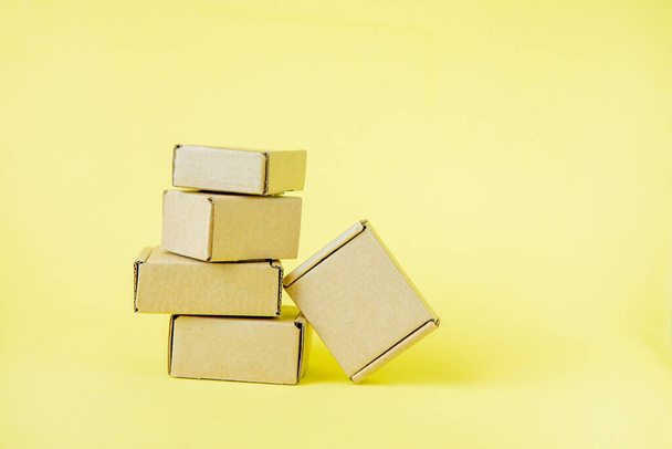 Cardboard boxes of various sizes on yellow background - Foto, immagini