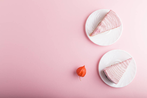 ピンクのパステルカラーの背景に自家製ピンクチーズケーキ。トップビュー、フラットレイ、コピースペース。ミニマリズムの概念. - 写真・画像