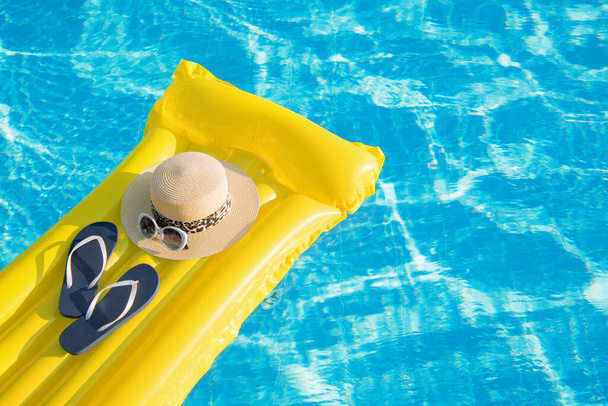 Plage vacances d'été fond. Matelas gonflable, tongs et chapeau sur la piscine. - Photo, image