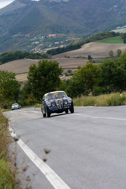 CAGLI, ITALIA - OTT 24 - 2020: LANCIA AURELIA B20 GT 2500 1953 en un viejo coche de carreras en el rally Mille Miglia 2020 la famosa carrera histórica italiana (1927-1957) - Foto, imagen