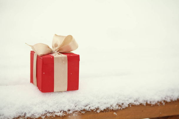 red Christmas gift box in the winter snow outdoors. - Foto, Imagen