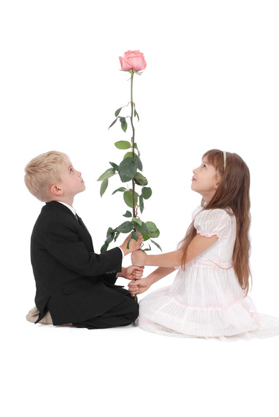 The boy and the girl look at a rose - Foto, imagen