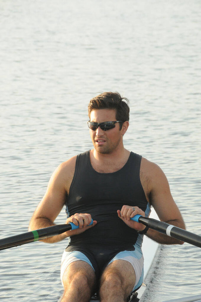 Rower and his single scull (shell) going out for some exercise on the water - Photo, Image